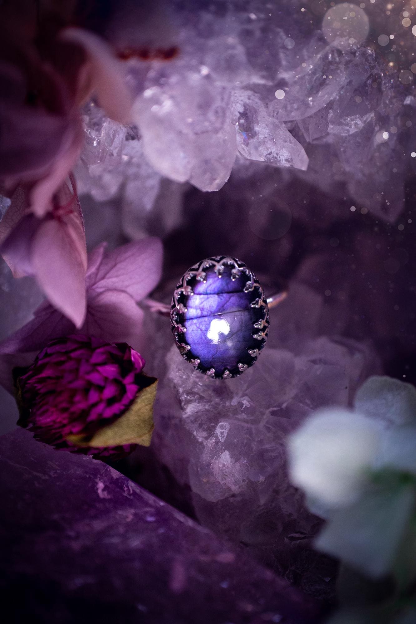 Handmade and very gothic, natural purple labradorite, sterling silver ring. This minimalist ring features a very pretty and flashy labradorite crystal that has a rich and vibrant purple colour. Around the crystal is a beautifully detail, gothic bezel that has been polished to a high lustre. The crystal is mounted on a 1.50mm ring shank. This ring would be ideal for anyone who loves jewellery and crystals, or who has a gothic and witchy style. A beautiful piece of jewellery to add to a collection