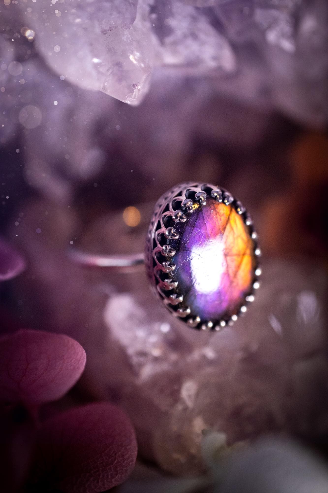 Handmade and very gothic, natural purple labradorite, sterling silver ring. This minimalist ring features a very pretty and flashy labradorite crystal that has a rich and vibrant purple colour. Around the crystal is a beautifully detail, gothic bezel that has been polished to a high lustre. The crystal is mounted on a 1.50mm ring shank. This ring would be ideal for anyone who loves jewellery and crystals, or who has a gothic and witchy style. A beautiful piece of jewellery to add to a collection