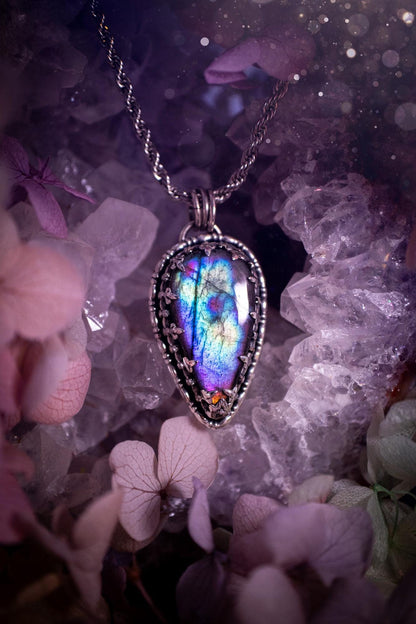Beautifully handcrafted, rainbow labradorite crystal pendant necklace. This beautiful pendant has been crafted out of sterling and fine silver and features a gothic bezel around the labradorite crystal. The labradorite in this piece is full of beautiful colours, purple, greens, blues with a bit of orange! A really stunning crystal. This jewellery piece would be ideal for anyone who is a fan of jewellery and crystals, and would make the ideal gift. Full of witchy and gothic vibes!