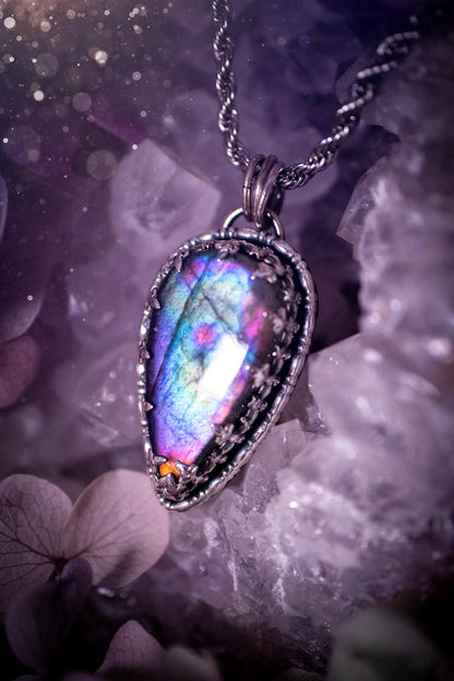 Beautifully handcrafted, rainbow labradorite crystal pendant necklace. This beautiful pendant has been crafted out of sterling and fine silver and features a gothic bezel around the labradorite crystal. The labradorite in this piece is full of beautiful colours, purple, greens, blues with a bit of orange! A really stunning crystal. This jewellery piece would be ideal for anyone who is a fan of jewellery and crystals, and would make the ideal gift. Full of witchy and gothic vibes!
