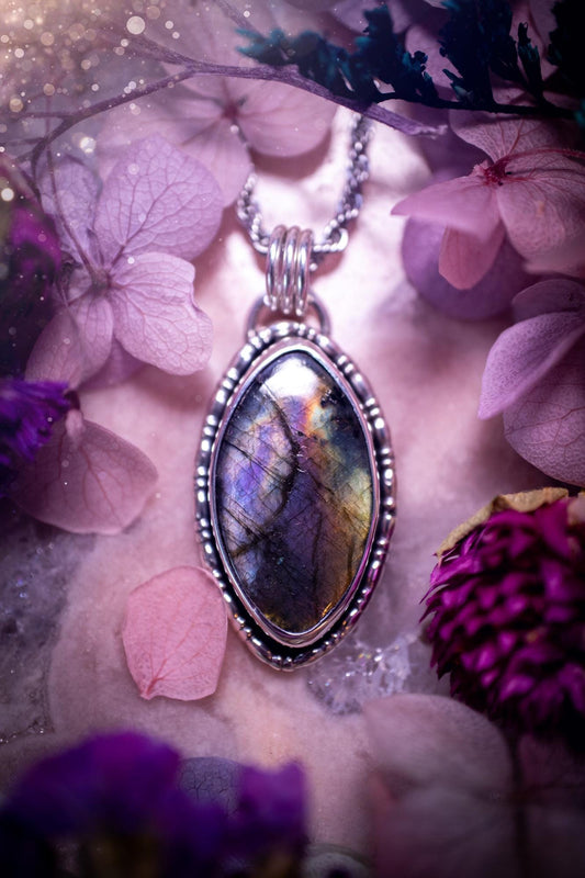 Beautifully handcrafted, rainbow labradorite crystal pendant necklace. This beautiful pendant has been crafted out of sterling and fine silver and features gothic bezel wire around the labradorite crystal. The labradorite in this piece is full of beautiful colours, purple, silvers, blues with a bit of orange! A really stunning crystal. This jewellery piece would be ideal for anyone who is a fan of jewellery and crystals, and would make the ideal gift. Full of witchy and gothic vibes!