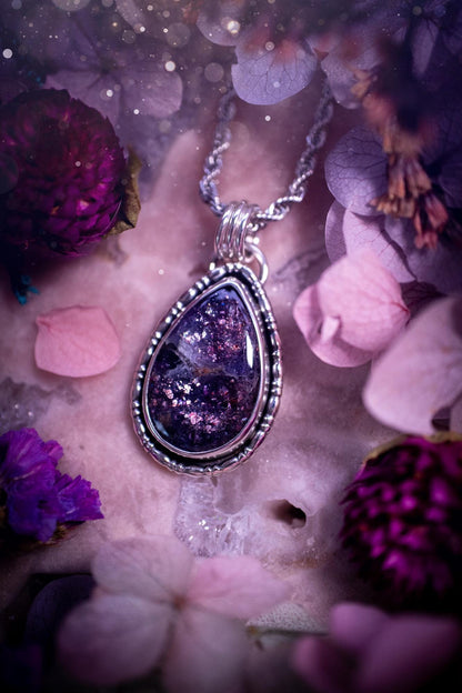 Stunning and handcrafted, natural Iolite sunstone, crystal pendant necklace. This beautiful pendant features a very sparkly iolite sunstone crystal that looks just like the galaxy, full of sparkle and pink shimmer. Made from a mix of sterling and fine silver, this piece is full of gothic vibes and has a gothic gallery wire around the crystal. Small and dainty. This piece would be suitable for gifting to jewellery and crystal lovers. Very witchy, gothic and hippy!