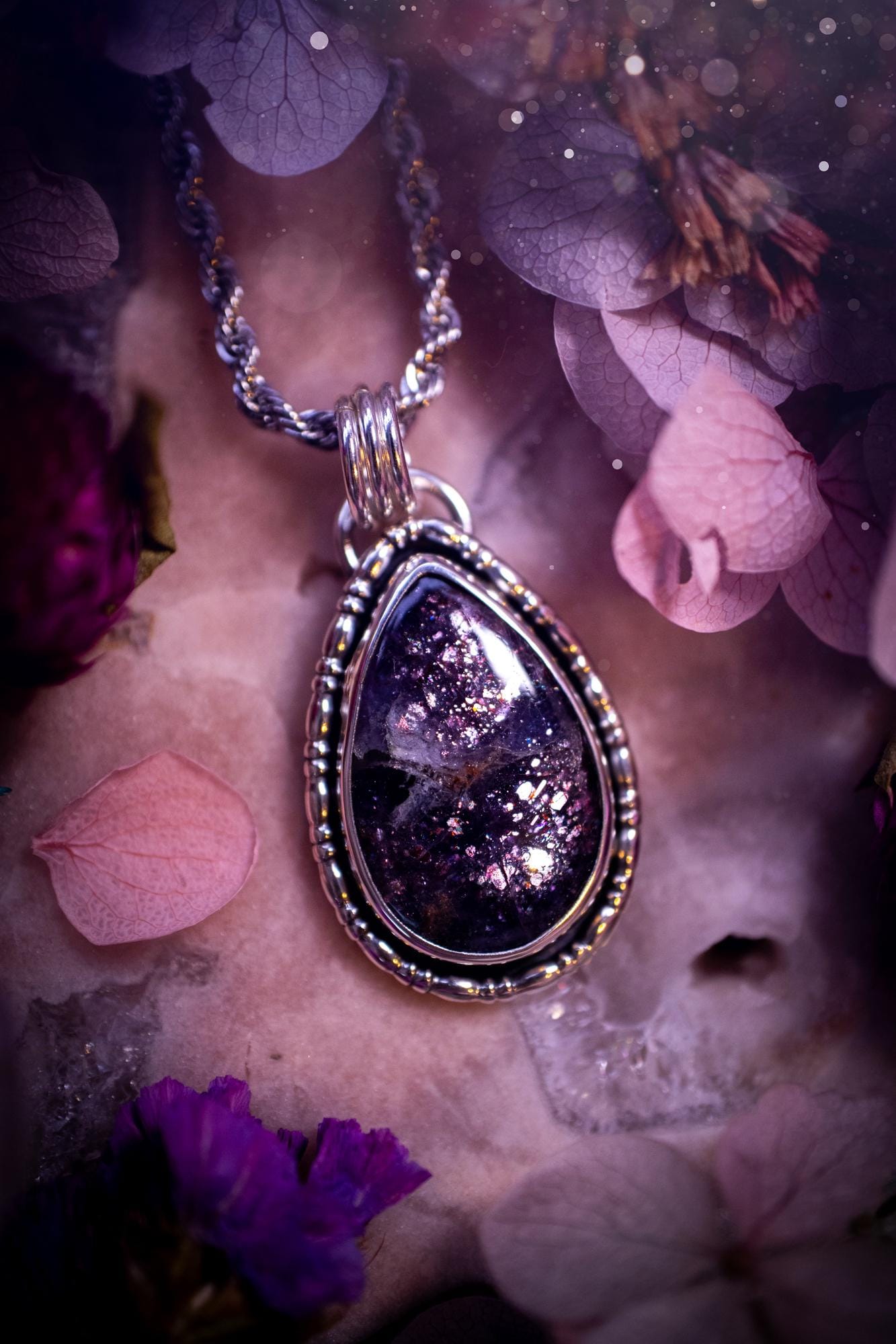 Stunning and handcrafted, natural Iolite sunstone, crystal pendant necklace. This beautiful pendant features a very sparkly iolite sunstone crystal that looks just like the galaxy, full of sparkle and pink shimmer. Made from a mix of sterling and fine silver, this piece is full of gothic vibes and has a gothic gallery wire around the crystal. Small and dainty. This piece would be suitable for gifting to jewellery and crystal lovers. Very witchy, gothic and hippy!
