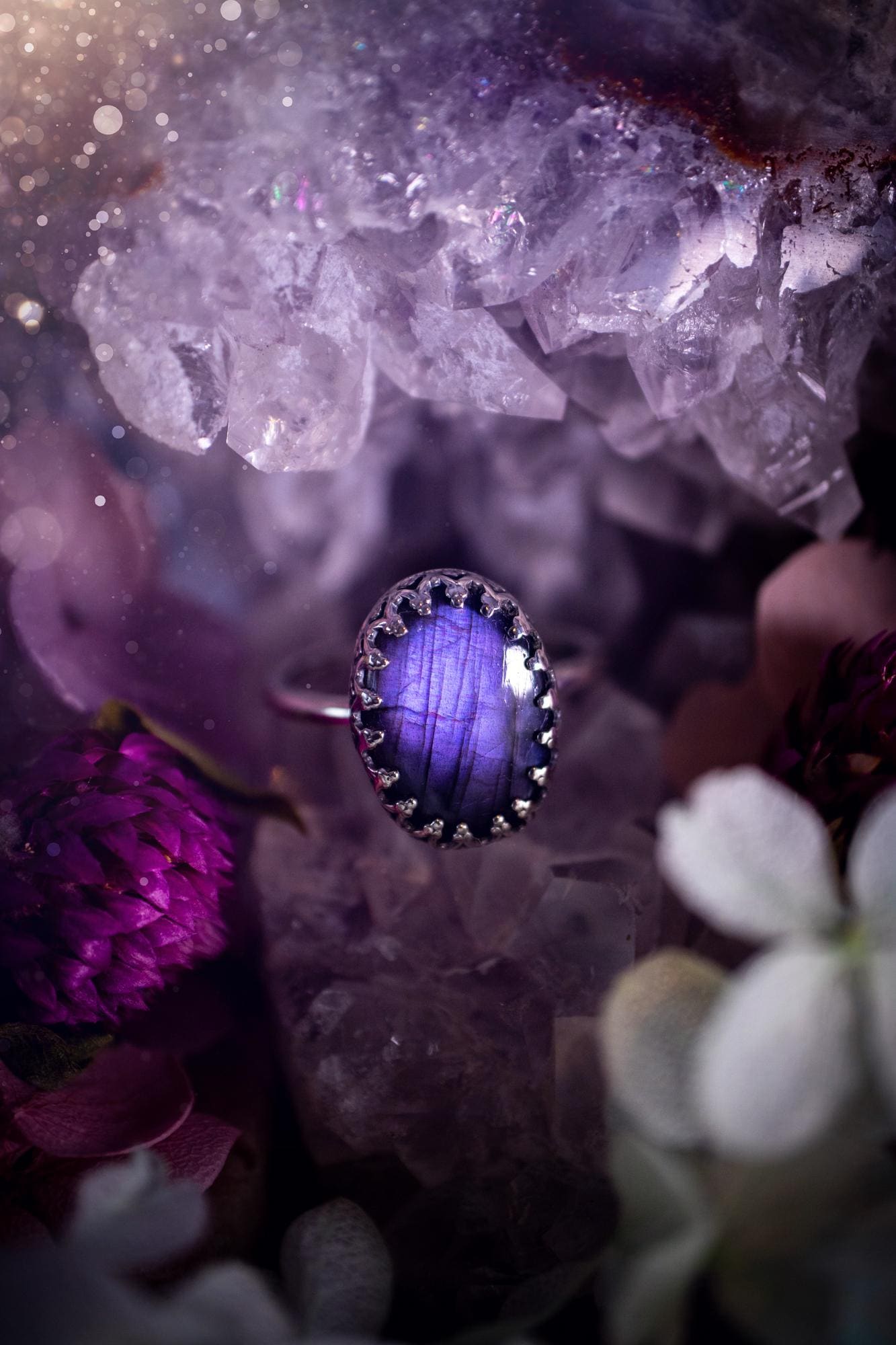 Handmade and very gothic, natural purple labradorite, sterling silver ring. This minimalist ring features a very pretty and flashy labradorite crystal that has a rich and vibrant purple colour. Around the crystal is a beautifully detail, gothic bezel that has been polished to a high lustre. The crystal is mounted on a 1.50mm ring shank. This ring would be ideal for anyone who loves jewellery and crystals, or who has a gothic and witchy style. A beautiful piece of jewellery to add to a collection