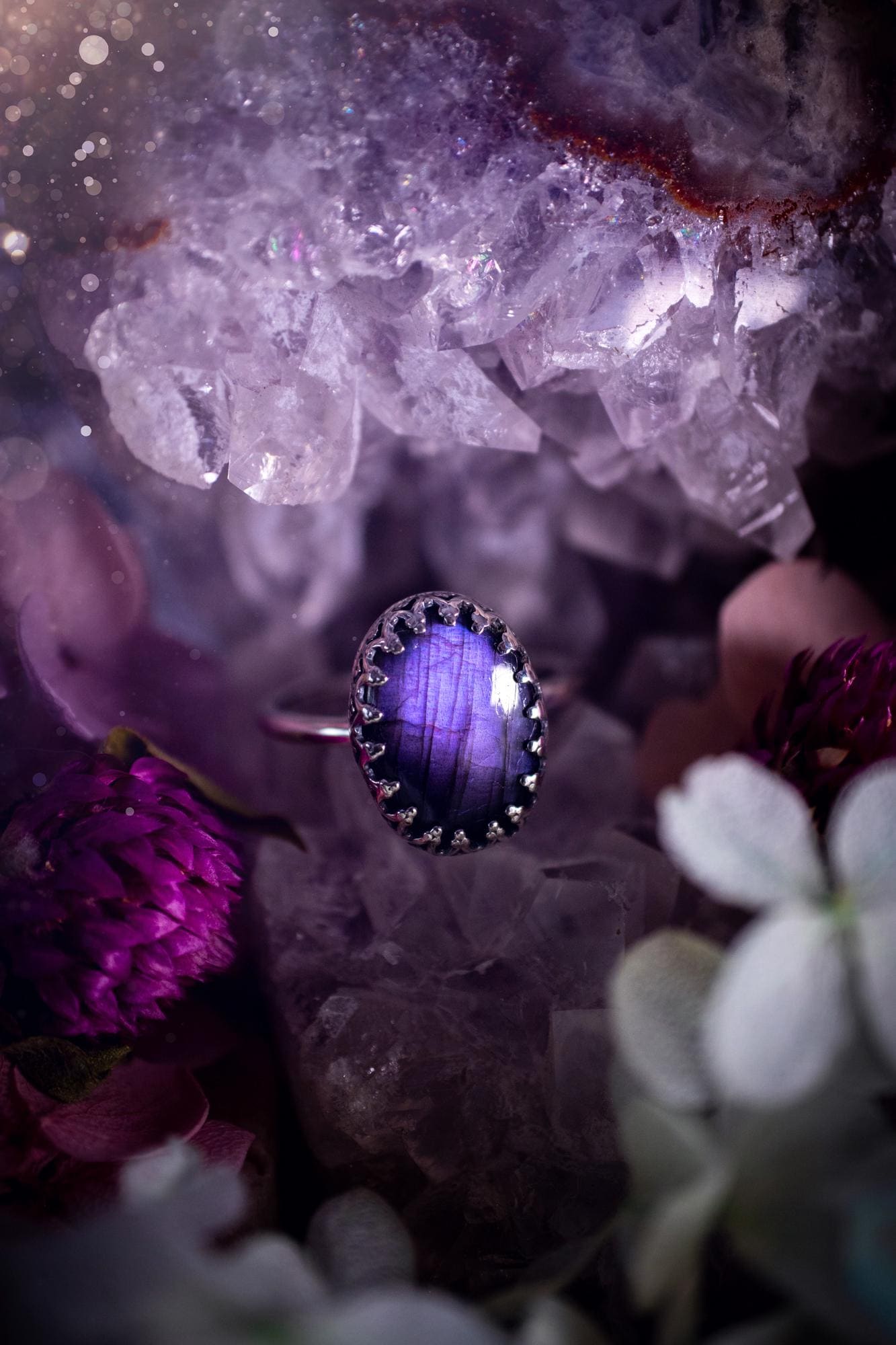 Handmade and very gothic, natural purple labradorite, sterling silver ring. This minimalist ring features a very pretty and flashy labradorite crystal that has a rich and vibrant purple colour. Around the crystal is a beautifully detail, gothic bezel that has been polished to a high lustre. The crystal is mounted on a 1.50mm ring shank. This ring would be ideal for anyone who loves jewellery and crystals, or who has a gothic and witchy style. A beautiful piece of jewellery to add to a collection