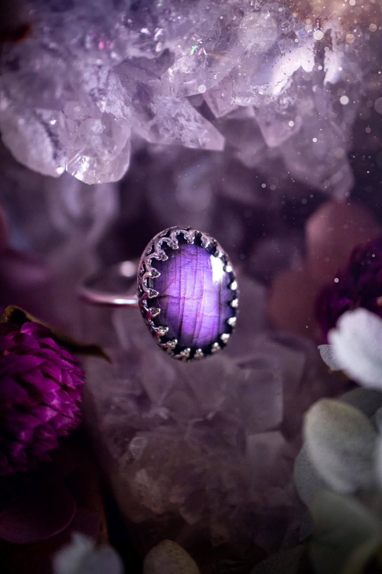 Handmade and very gothic, natural purple labradorite, sterling silver ring. This minimalist ring features a very pretty and flashy labradorite crystal that has a rich and vibrant purple colour. Around the crystal is a beautifully detail, gothic bezel that has been polished to a high lustre. The crystal is mounted on a 1.50mm ring shank. This ring would be ideal for anyone who loves jewellery and crystals, or who has a gothic and witchy style. A beautiful piece of jewellery to add to a collection