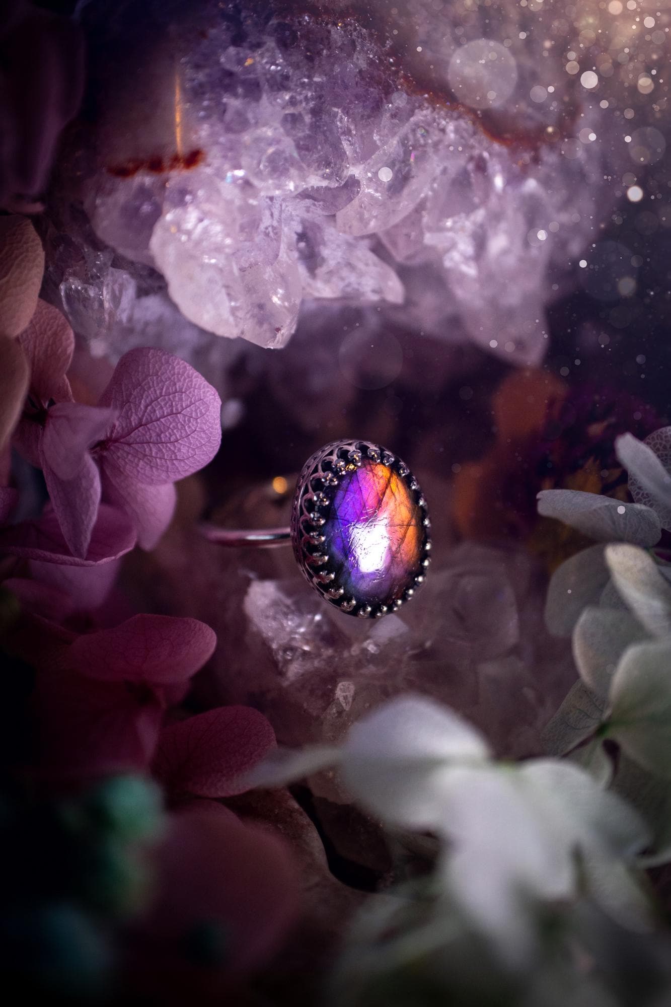 Handmade and very gothic, natural purple labradorite, sterling silver ring. This minimalist ring features a very pretty and flashy labradorite crystal that has a rich and vibrant purple colour. Around the crystal is a beautifully detail, gothic bezel that has been polished to a high lustre. The crystal is mounted on a 1.50mm ring shank. This ring would be ideal for anyone who loves jewellery and crystals, or who has a gothic and witchy style. A beautiful piece of jewellery to add to a collection