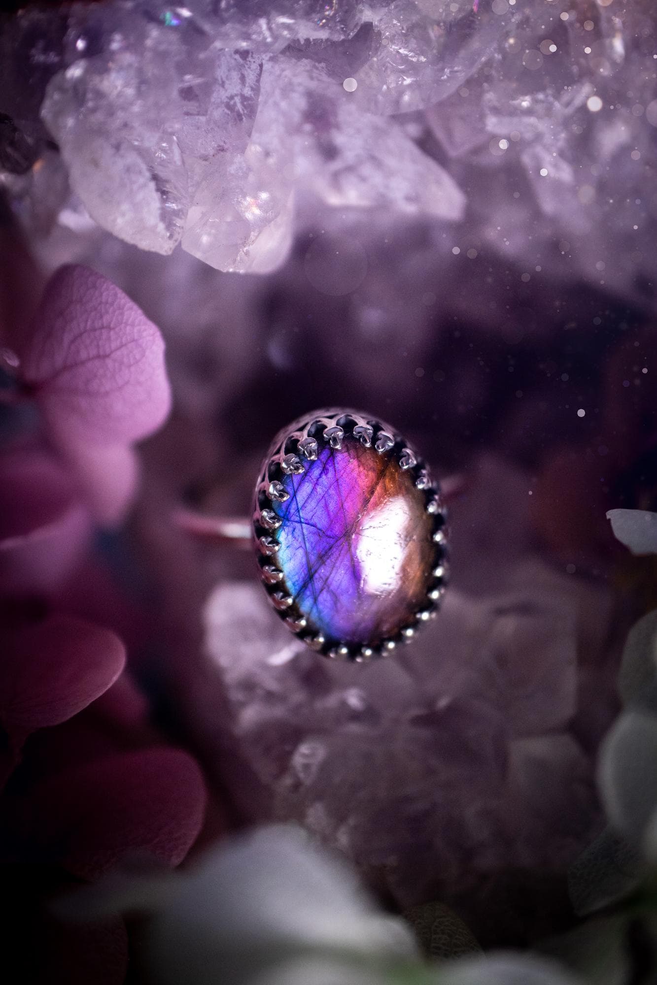 Handmade and very gothic, natural purple labradorite, sterling silver ring. This minimalist ring features a very pretty and flashy labradorite crystal that has a rich and vibrant purple colour. Around the crystal is a beautifully detail, gothic bezel that has been polished to a high lustre. The crystal is mounted on a 1.50mm ring shank. This ring would be ideal for anyone who loves jewellery and crystals, or who has a gothic and witchy style. A beautiful piece of jewellery to add to a collection