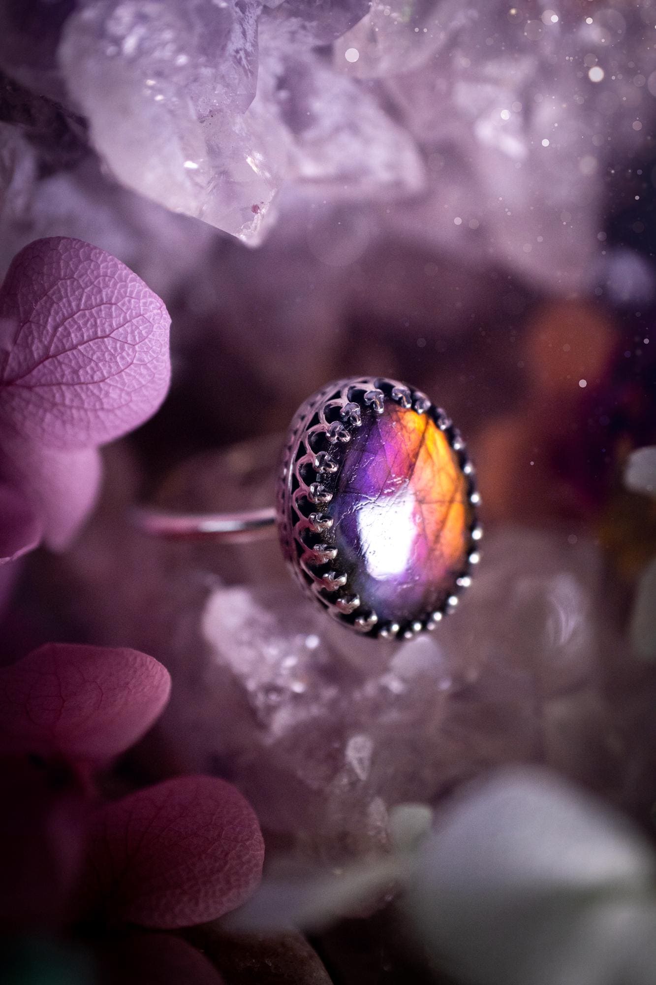 Handmade and very gothic, natural purple labradorite, sterling silver ring. This minimalist ring features a very pretty and flashy labradorite crystal that has a rich and vibrant purple colour. Around the crystal is a beautifully detail, gothic bezel that has been polished to a high lustre. The crystal is mounted on a 1.50mm ring shank. This ring would be ideal for anyone who loves jewellery and crystals, or who has a gothic and witchy style. A beautiful piece of jewellery to add to a collection