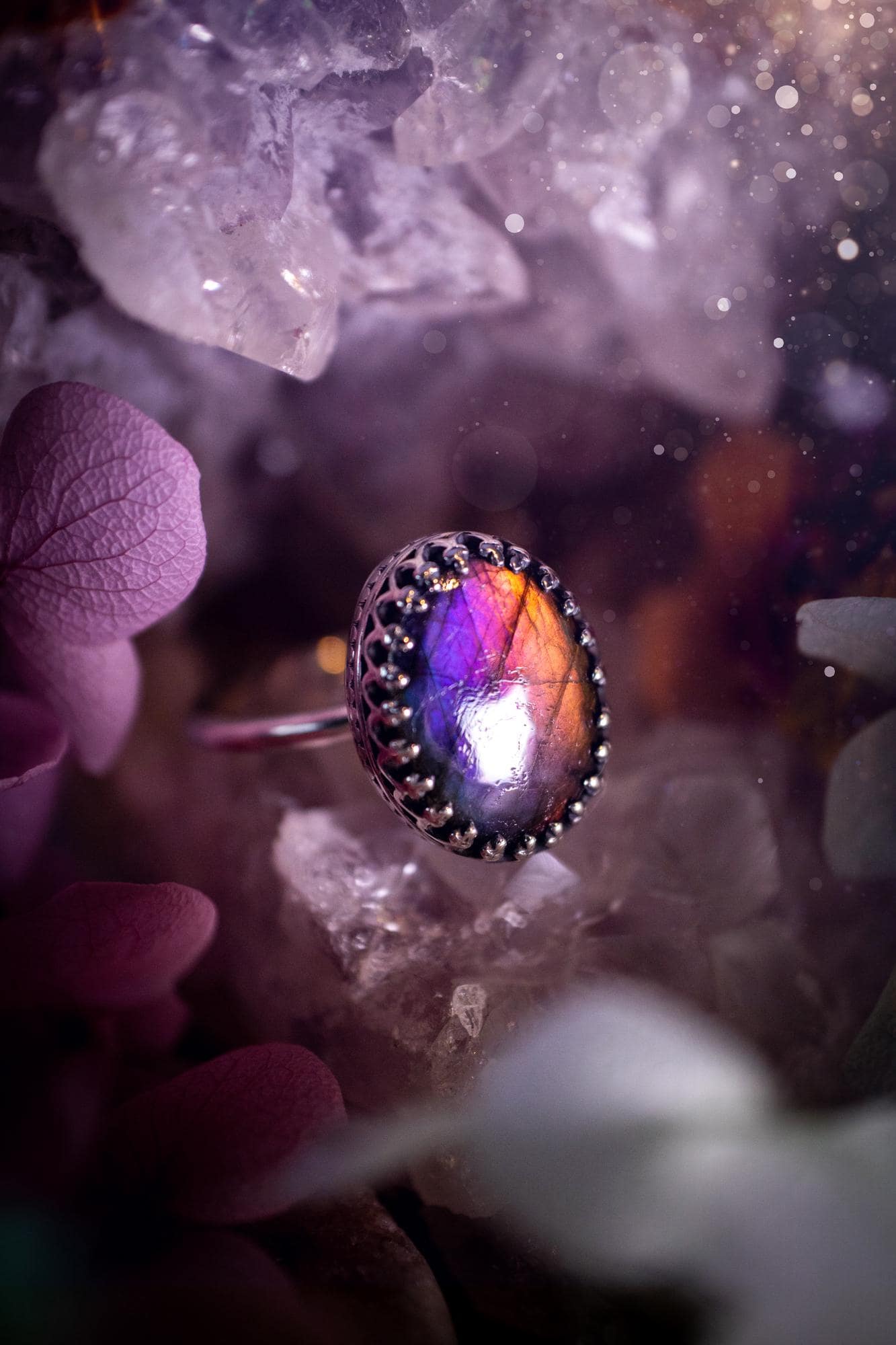 Handmade and very gothic, natural purple labradorite, sterling silver ring. This minimalist ring features a very pretty and flashy labradorite crystal that has a rich and vibrant purple colour. Around the crystal is a beautifully detail, gothic bezel that has been polished to a high lustre. The crystal is mounted on a 1.50mm ring shank. This ring would be ideal for anyone who loves jewellery and crystals, or who has a gothic and witchy style. A beautiful piece of jewellery to add to a collection