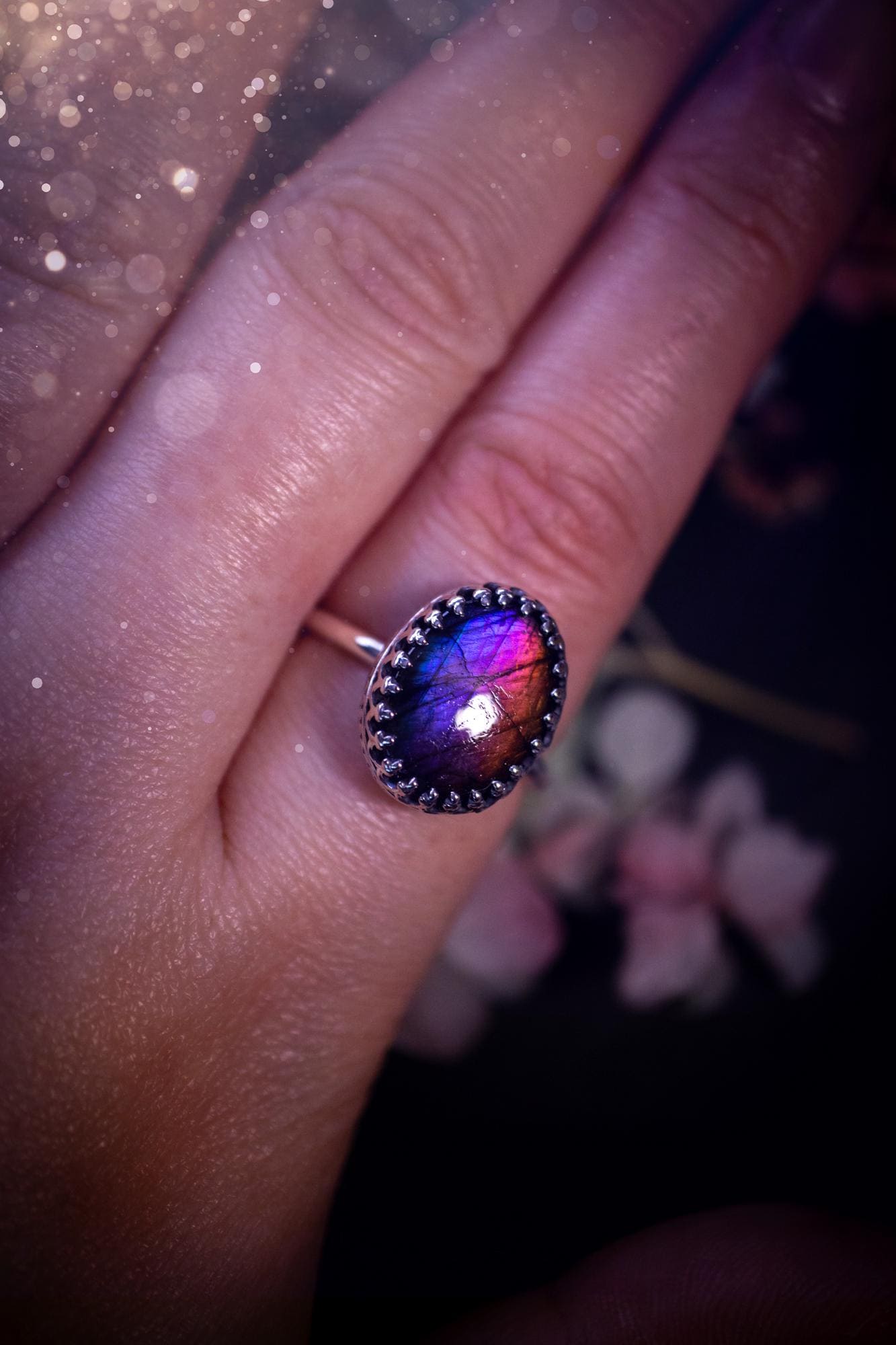 Handmade and very gothic, natural purple labradorite, sterling silver ring. This minimalist ring features a very pretty and flashy labradorite crystal that has a rich and vibrant purple colour. Around the crystal is a beautifully detail, gothic bezel that has been polished to a high lustre. The crystal is mounted on a 1.50mm ring shank. This ring would be ideal for anyone who loves jewellery and crystals, or who has a gothic and witchy style. A beautiful piece of jewellery to add to a collection