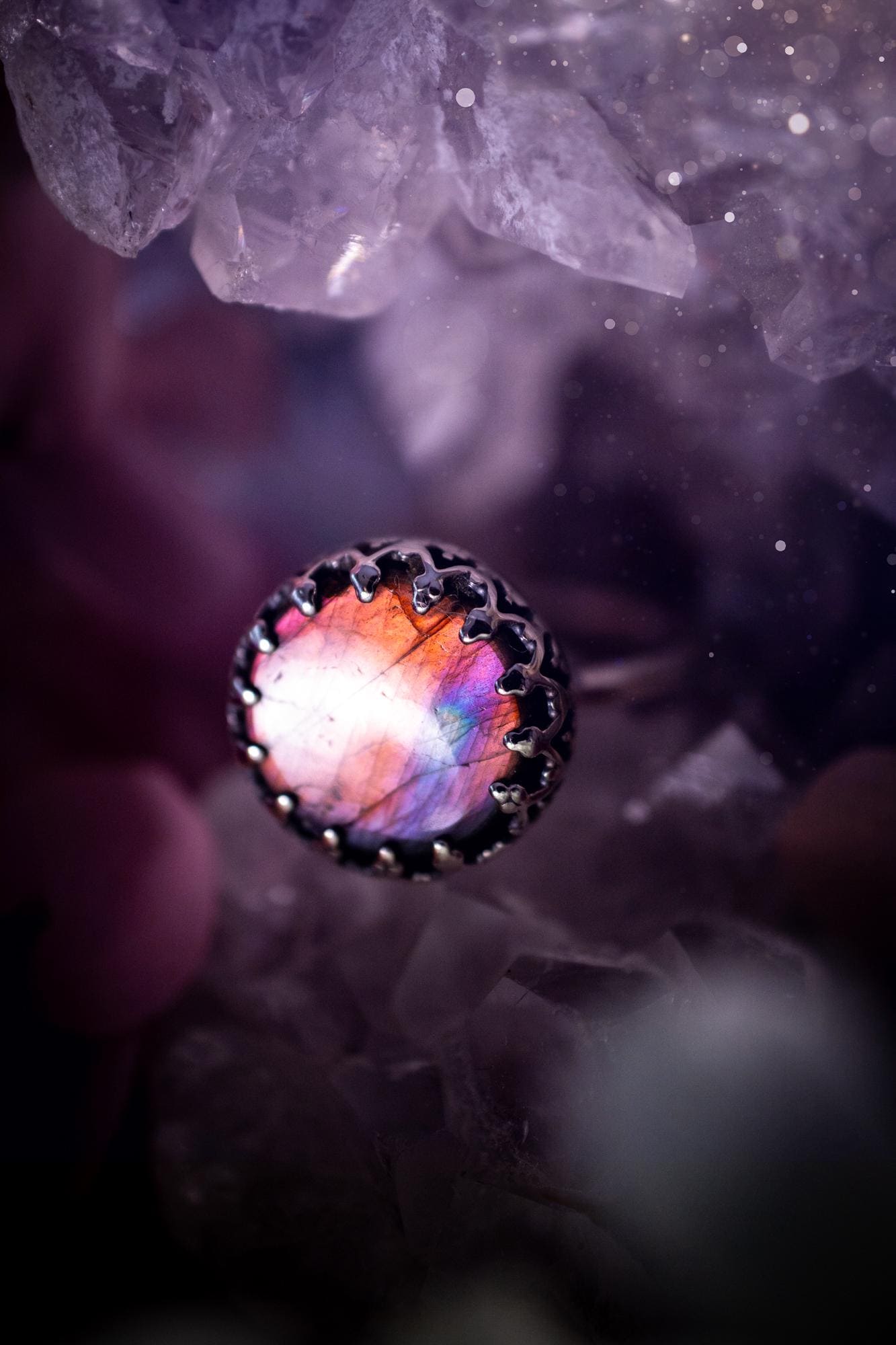 Handmade and very gothic, natural purple labradorite, sterling silver ring. This minimalist ring features a very pretty and flashy labradorite crystal that has a rich and vibrant purple colour. Around the crystal is a beautifully detail, gothic bezel that has been polished to a high lustre. The crystal is mounted on a 1.50mm ring shank. This ring would be ideal for anyone who loves jewellery and crystals, or who has a gothic and witchy style. A beautiful piece of jewellery to add to a collection