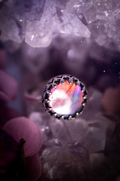 Handmade and very gothic, natural purple labradorite, sterling silver ring. This minimalist ring features a very pretty and flashy labradorite crystal that has a rich and vibrant purple colour. Around the crystal is a beautifully detail, gothic bezel that has been polished to a high lustre. The crystal is mounted on a 1.50mm ring shank. This ring would be ideal for anyone who loves jewellery and crystals, or who has a gothic and witchy style. A beautiful piece of jewellery to add to a collection