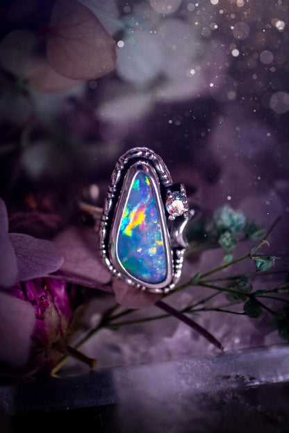 Handmade and totally bespoke, Australian Opal doublet, celestial style ring. This mini statement ring has been handmade using fine and sterling silver. Featuring a very beautiful and bold Australian Opal doublet that is full of colour play with lilac, reds, blues and greens that are super flashy! The ring is of a celestial style with a little moon and aurora coloured cubic zirconia to the side. This little ring would be suitable for anyone who loves crystals, opals and jewellery! Gothic vibes