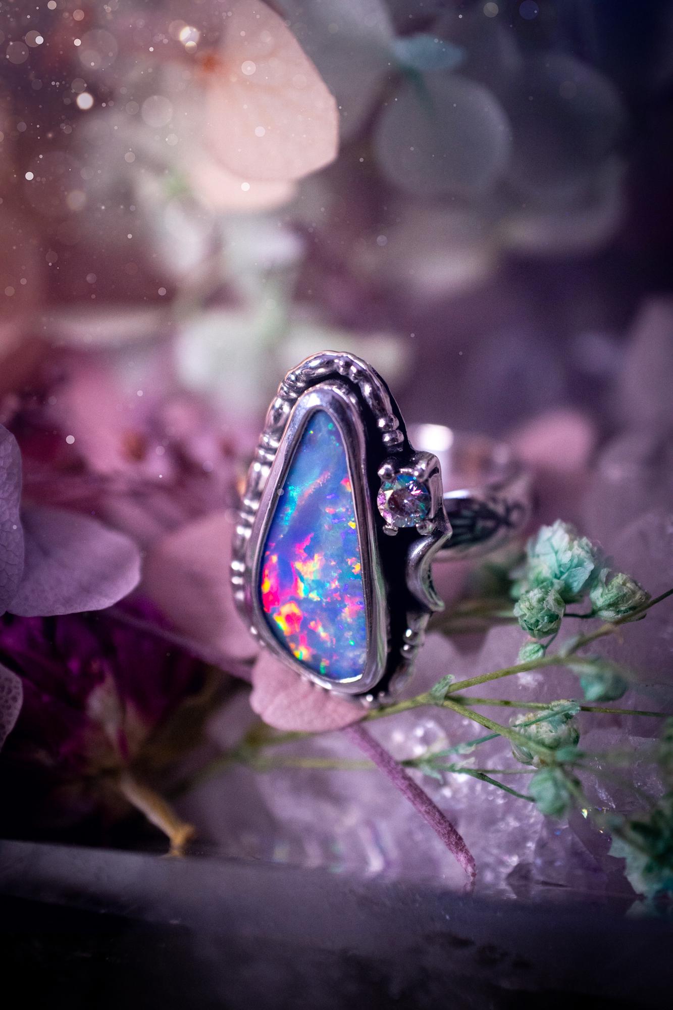 Handmade and totally bespoke, Australian Opal doublet, celestial style ring. This mini statement ring has been handmade using fine and sterling silver. Featuring a very beautiful and bold Australian Opal doublet that is full of colour play with lilac, reds, blues and greens that are super flashy! The ring is of a celestial style with a little moon and aurora coloured cubic zirconia to the side. This little ring would be suitable for anyone who loves crystals, opals and jewellery! Gothic vibes