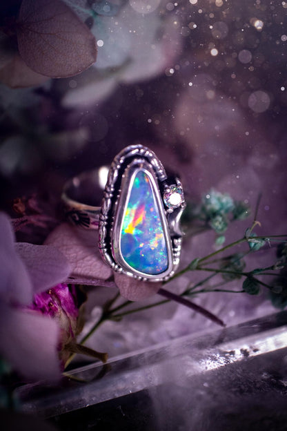 Handmade and totally bespoke, Australian Opal doublet, celestial style ring. This mini statement ring has been handmade using fine and sterling silver. Featuring a very beautiful and bold Australian Opal doublet that is full of colour play with lilac, reds, blues and greens that are super flashy! The ring is of a celestial style with a little moon and aurora coloured cubic zirconia to the side. This little ring would be suitable for anyone who loves crystals, opals and jewellery! Gothic vibes