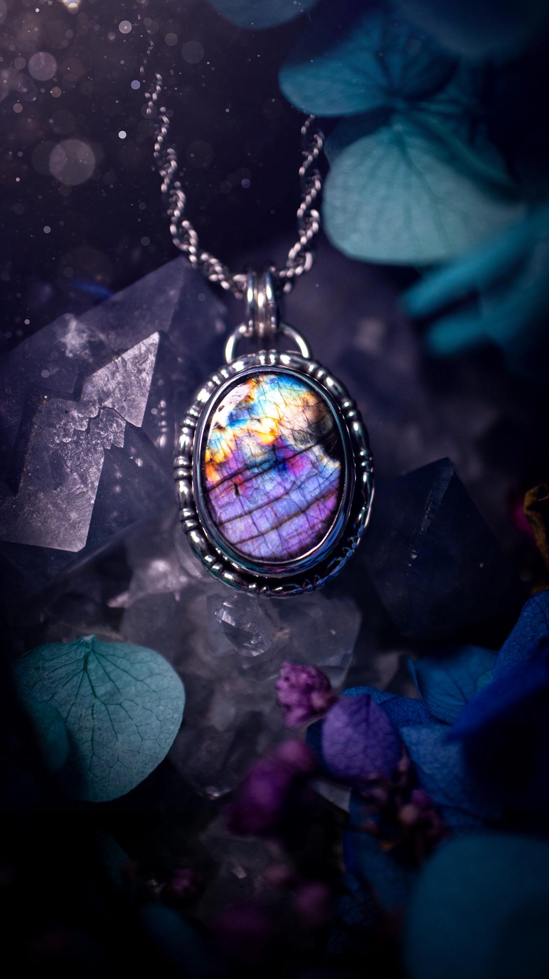 Beautifully handcrafted, rainbow labradorite crystal pendant necklace. This beautiful pendant has been crafted out of sterling and fine silver and features gothic bezel wire around the labradorite crystal. The labradorite in this piece is full of beautiful colours, purple, pinks and colours of the rainbow! This jewellery piece would be ideal for anyone who is a fan of jewellery and crystals, and would make the ideal gift. Full of witchy and gothic vibes!