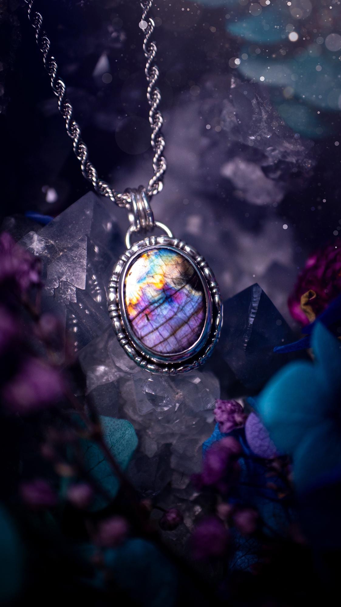 Beautifully handcrafted, rainbow labradorite crystal pendant necklace. This beautiful pendant has been crafted out of sterling and fine silver and features gothic bezel wire around the labradorite crystal. The labradorite in this piece is full of beautiful colours, purple, pinks and colours of the rainbow! This jewellery piece would be ideal for anyone who is a fan of jewellery and crystals, and would make the ideal gift. Full of witchy and gothic vibes!