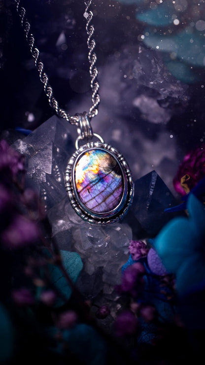 Beautifully handcrafted, rainbow labradorite crystal pendant necklace. This beautiful pendant has been crafted out of sterling and fine silver and features gothic bezel wire around the labradorite crystal. The labradorite in this piece is full of beautiful colours, purple, pinks and colours of the rainbow! This jewellery piece would be ideal for anyone who is a fan of jewellery and crystals, and would make the ideal gift. Full of witchy and gothic vibes!