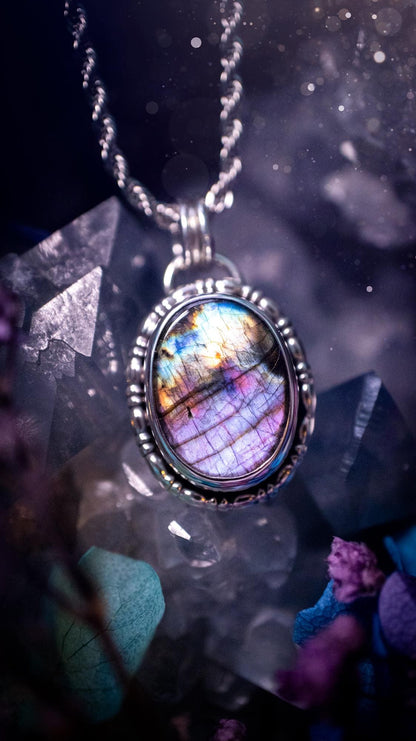 Beautifully handcrafted, rainbow labradorite crystal pendant necklace. This beautiful pendant has been crafted out of sterling and fine silver and features gothic bezel wire around the labradorite crystal. The labradorite in this piece is full of beautiful colours, purple, pinks and colours of the rainbow! This jewellery piece would be ideal for anyone who is a fan of jewellery and crystals, and would make the ideal gift. Full of witchy and gothic vibes!
