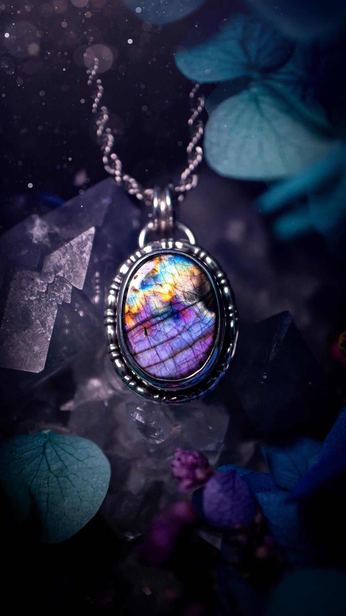 Beautifully handcrafted, rainbow labradorite crystal pendant necklace. This beautiful pendant has been crafted out of sterling and fine silver and features gothic bezel wire around the labradorite crystal. The labradorite in this piece is full of beautiful colours, purple, pinks and colours of the rainbow! This jewellery piece would be ideal for anyone who is a fan of jewellery and crystals, and would make the ideal gift. Full of witchy and gothic vibes!