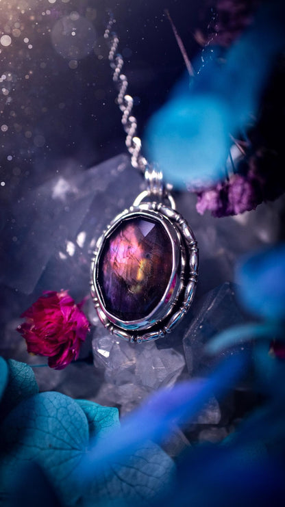 Beautifully handcrafted, rainbow labradorite crystal pendant necklace. This beautiful pendant has been crafted out of sterling and fine silver and features gothic bezel wire around the labradorite crystal. The labradorite in this piece is full of beautiful colours, purple, with a bit of orange! On top of the labradorite is Himalayan Quartz. This jewellery piece would be ideal for anyone who is a fan of jewellery and crystals, and would make the ideal gift. Full of witchy and gothic vibes!