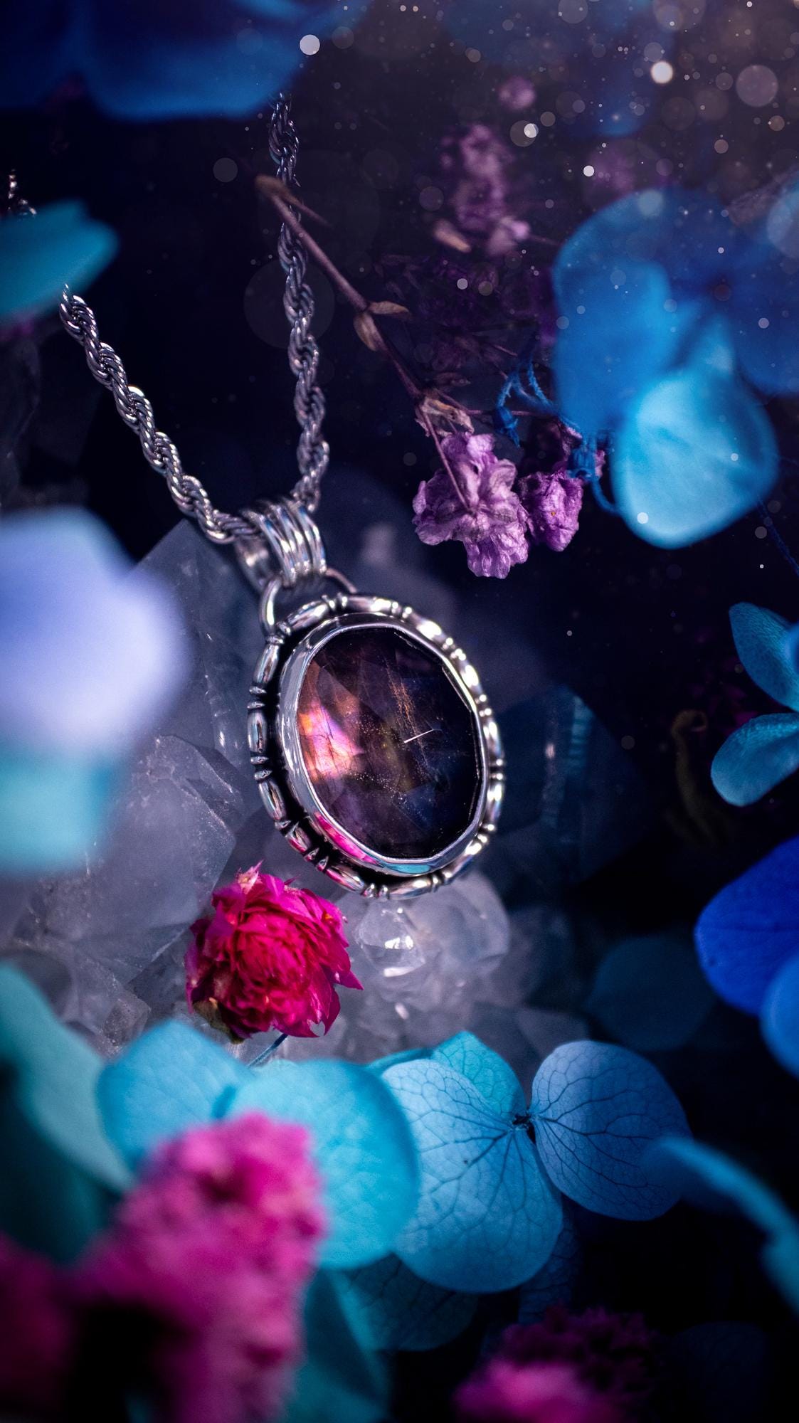 Beautifully handcrafted, rainbow labradorite crystal pendant necklace. This beautiful pendant has been crafted out of sterling and fine silver and features gothic bezel wire around the labradorite crystal. The labradorite in this piece is full of beautiful colours, purple, with a bit of orange! On top of the labradorite is Himalayan Quartz. This jewellery piece would be ideal for anyone who is a fan of jewellery and crystals, and would make the ideal gift. Full of witchy and gothic vibes!