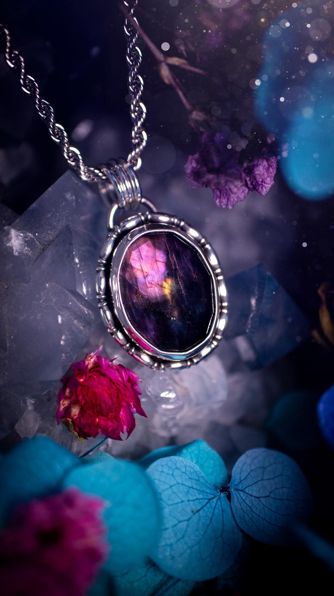 Beautifully handcrafted, rainbow labradorite crystal pendant necklace. This beautiful pendant has been crafted out of sterling and fine silver and features gothic bezel wire around the labradorite crystal. The labradorite in this piece is full of beautiful colours, purple, with a bit of orange! On top of the labradorite is Himalayan Quartz. This jewellery piece would be ideal for anyone who is a fan of jewellery and crystals, and would make the ideal gift. Full of witchy and gothic vibes!