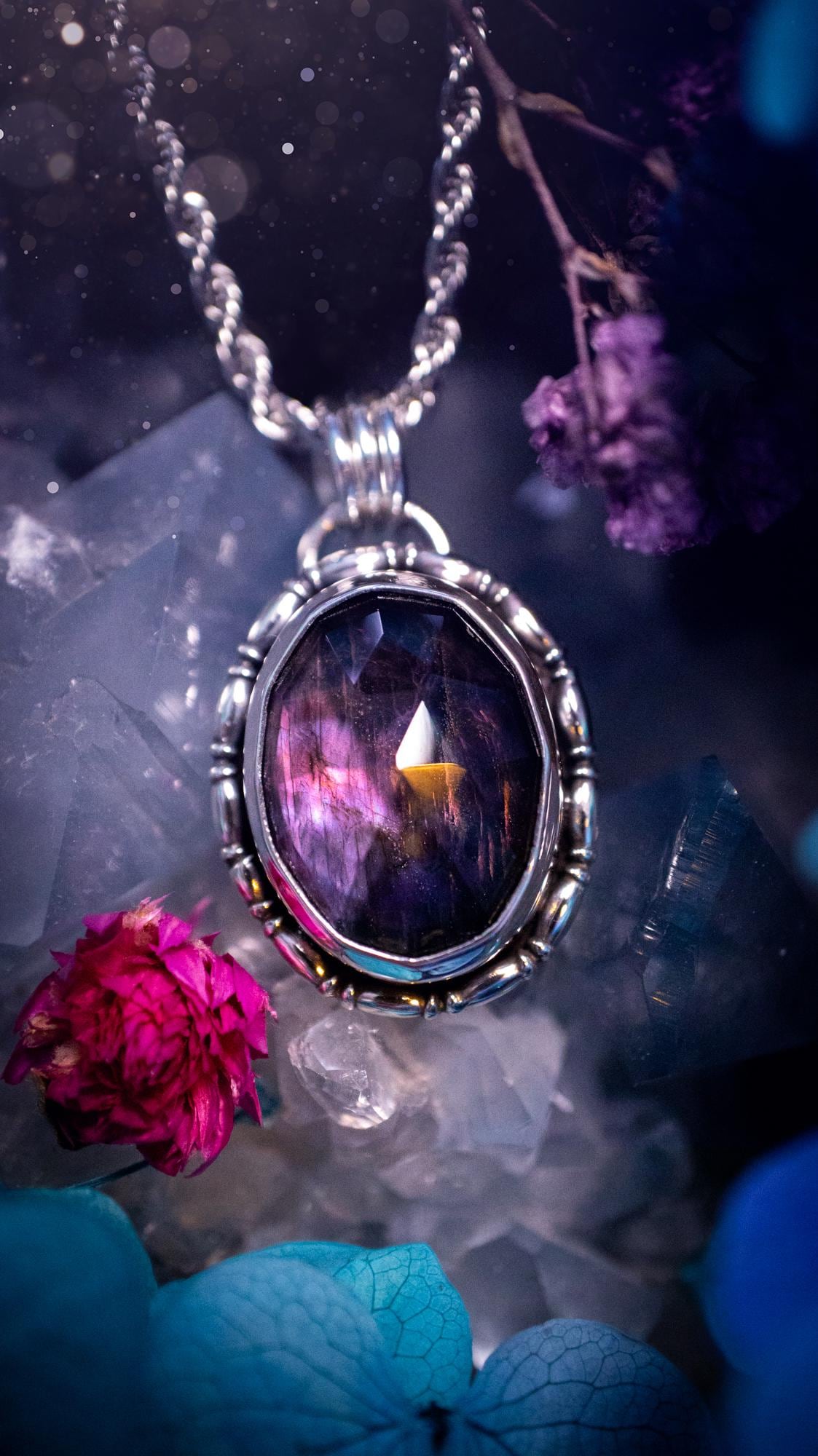 Beautifully handcrafted, rainbow labradorite crystal pendant necklace. This beautiful pendant has been crafted out of sterling and fine silver and features gothic bezel wire around the labradorite crystal. The labradorite in this piece is full of beautiful colours, purple, with a bit of orange! On top of the labradorite is Himalayan Quartz. This jewellery piece would be ideal for anyone who is a fan of jewellery and crystals, and would make the ideal gift. Full of witchy and gothic vibes!