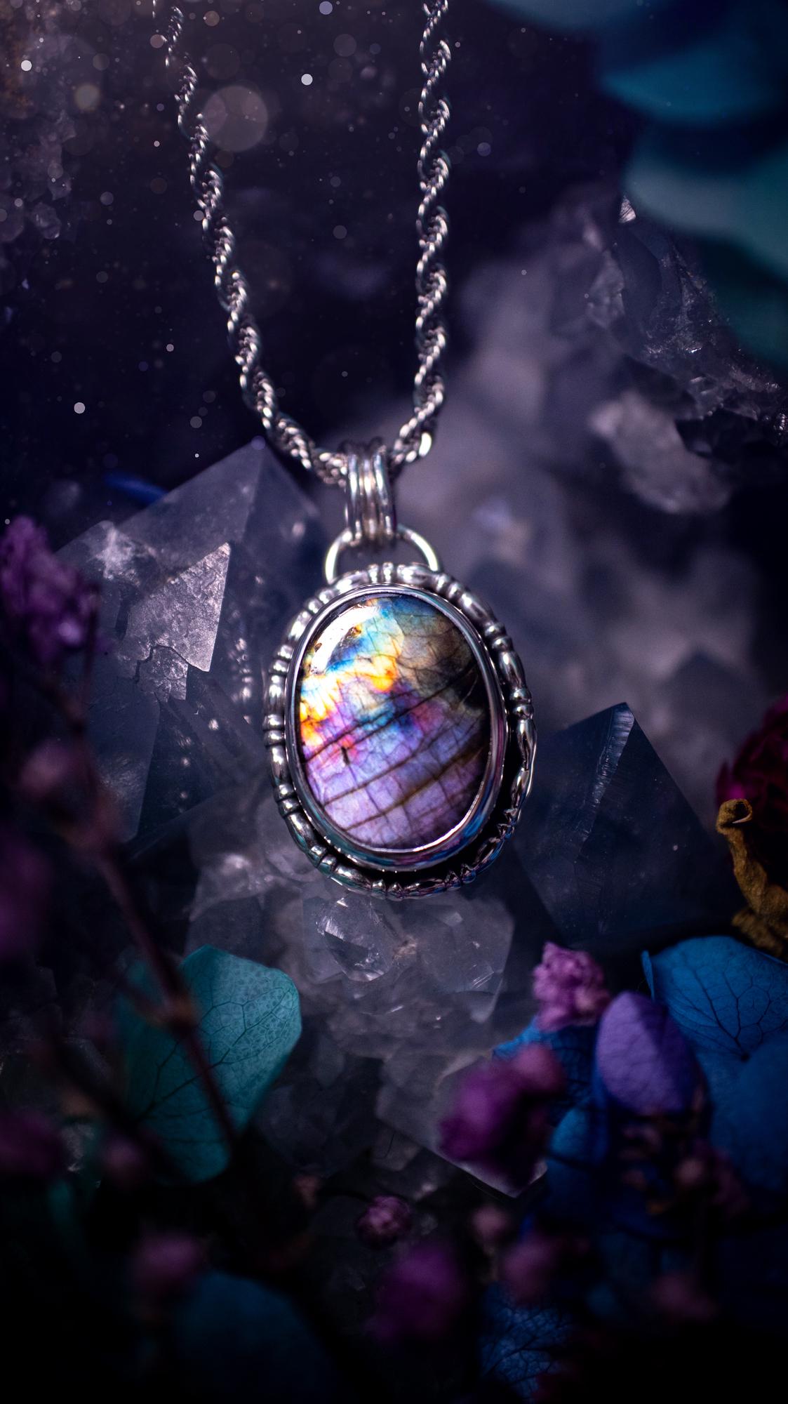 Beautifully handcrafted, rainbow labradorite crystal pendant necklace. This beautiful pendant has been crafted out of sterling and fine silver and features gothic bezel wire around the labradorite crystal. The labradorite in this piece is full of beautiful colours, purple, pinks and colours of the rainbow! This jewellery piece would be ideal for anyone who is a fan of jewellery and crystals, and would make the ideal gift. Full of witchy and gothic vibes!