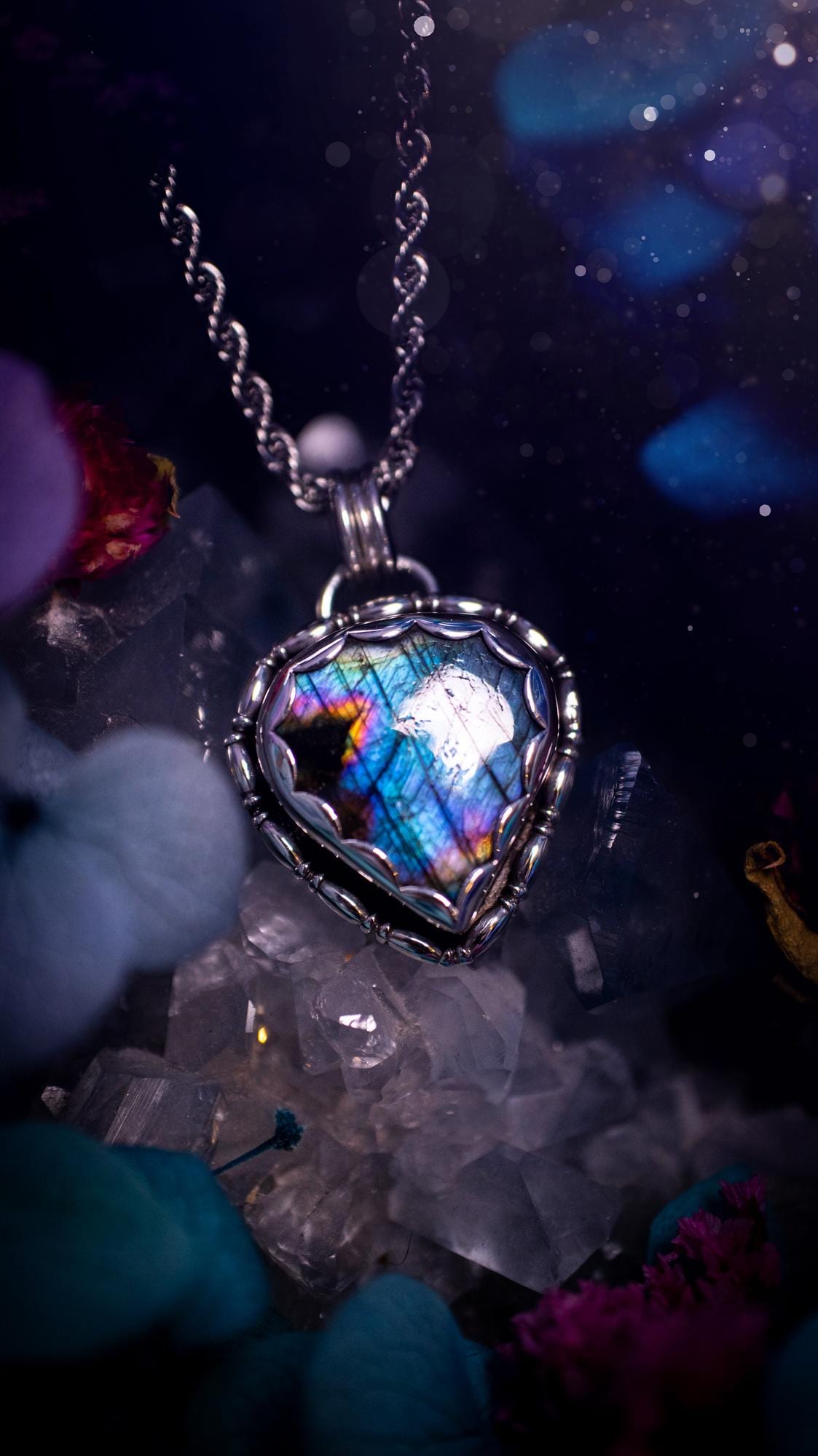 Beautifully handcrafted, rainbow labradorite crystal pendant necklace. This beautiful pendant has been crafted out of sterling and fine silver and features gothic bezel wire around the labradorite crystal in a scallop bezel. The labradorite in this piece is full of beautiful colours, purple, pinks and colours of the rainbow! This jewellery piece would be ideal for anyone who is a fan of jewellery and crystals, and would make the ideal gift. Full of witchy and gothic vibes!