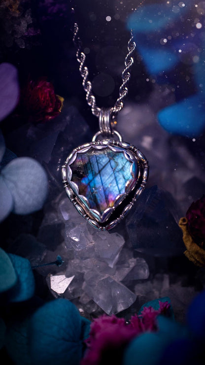 Beautifully handcrafted, rainbow labradorite crystal pendant necklace. This beautiful pendant has been crafted out of sterling and fine silver and features gothic bezel wire around the labradorite crystal in a scallop bezel. The labradorite in this piece is full of beautiful colours, purple, pinks and colours of the rainbow! This jewellery piece would be ideal for anyone who is a fan of jewellery and crystals, and would make the ideal gift. Full of witchy and gothic vibes!
