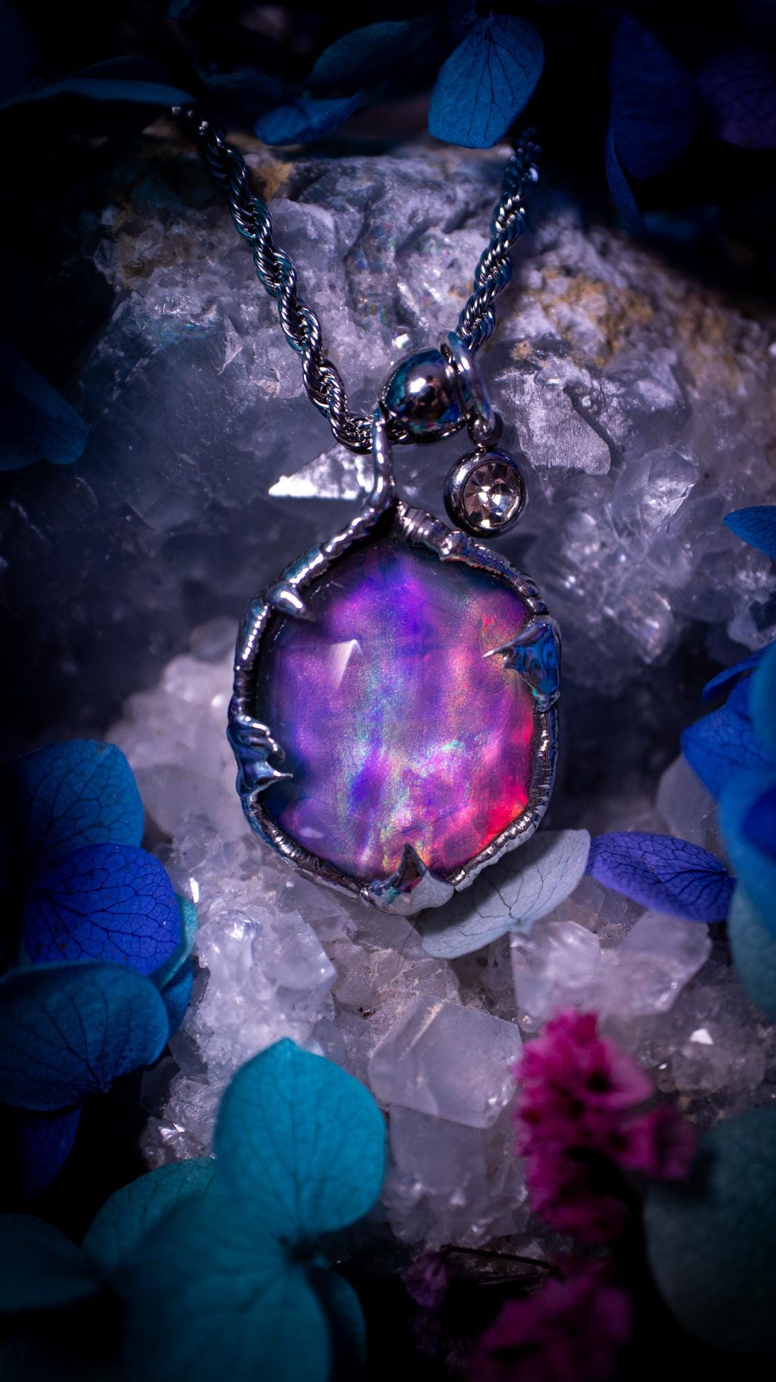 A beautiful, one of a kind, aurora opal pendant necklace. This little statement necklace is handmade using the tiffany technique, also known as soft soldering. Featuring the most stunning, and sparkly aurora opal which is full of pinks, greens and blues just like the northern lights. Aurora opals are man made opals that look similar to natural ones, they have a layer of rose quartz on top to give extra shine. The ideal gift for any crystal or jewellery lover. Gothic and witchy jewellery