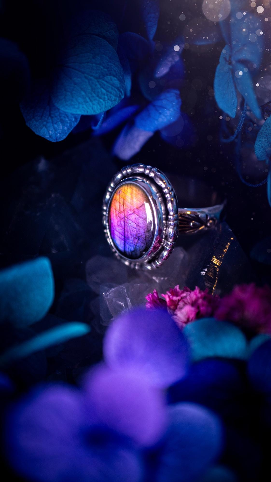 Handmade and very gothic, natural purple labradorite, sterling silver ring. This minimalist ring features a very pretty and flashy labradorite crystal that has a rich and vibrant purple colour. Around the crystal is a beautifully detail, gothic bezel that has been polished to a high lustre. The crystal is mounted on stamped ring shank. This ring would be ideal for anyone who loves jewellery and crystals, or who has a gothic and witchy style. A beautiful piece of jewellery to add to a collection