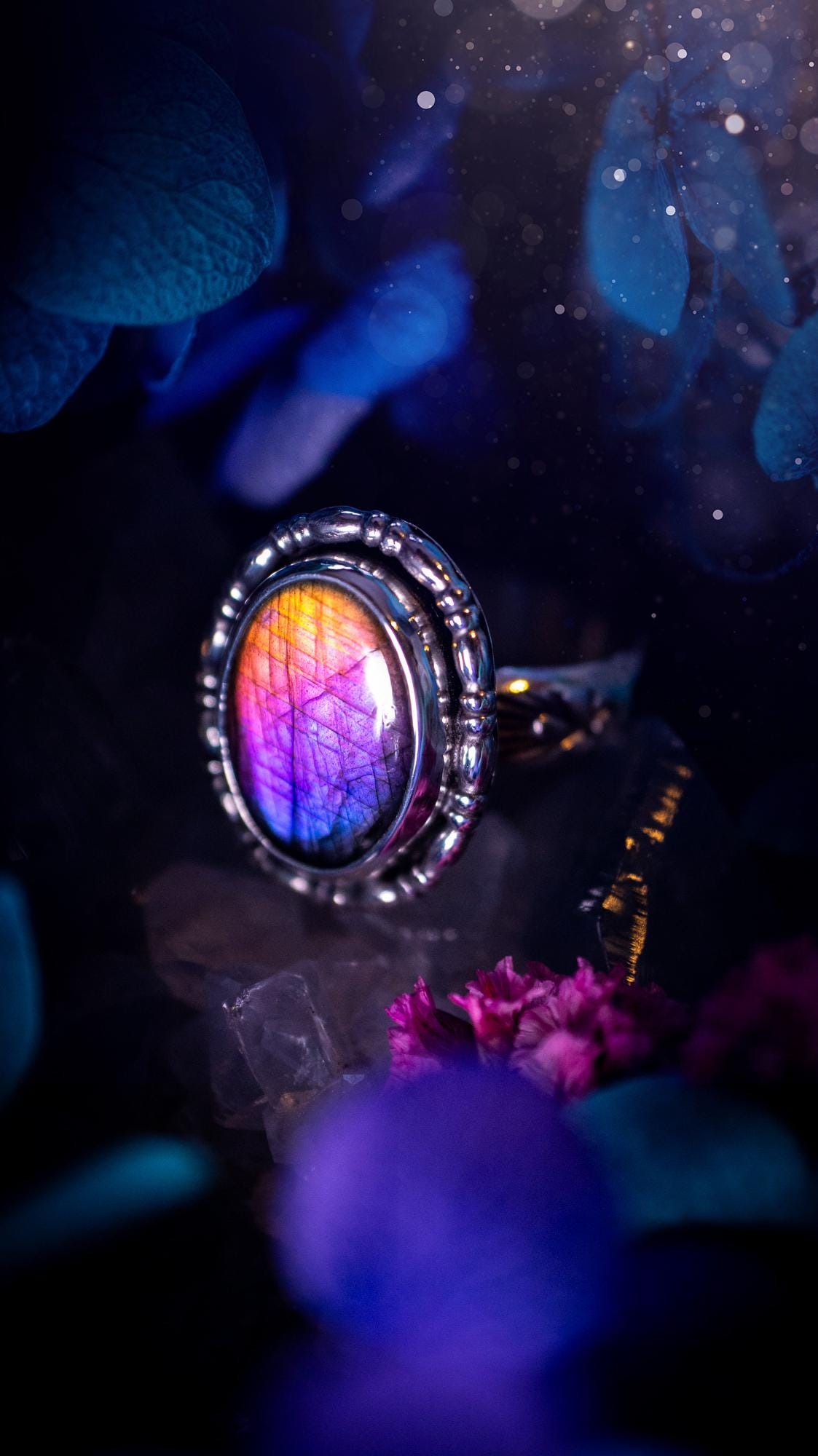 Handmade and very gothic, natural purple labradorite, sterling silver ring. This minimalist ring features a very pretty and flashy labradorite crystal that has a rich and vibrant purple colour. Around the crystal is a beautifully detail, gothic bezel that has been polished to a high lustre. The crystal is mounted on stamped ring shank. This ring would be ideal for anyone who loves jewellery and crystals, or who has a gothic and witchy style. A beautiful piece of jewellery to add to a collection