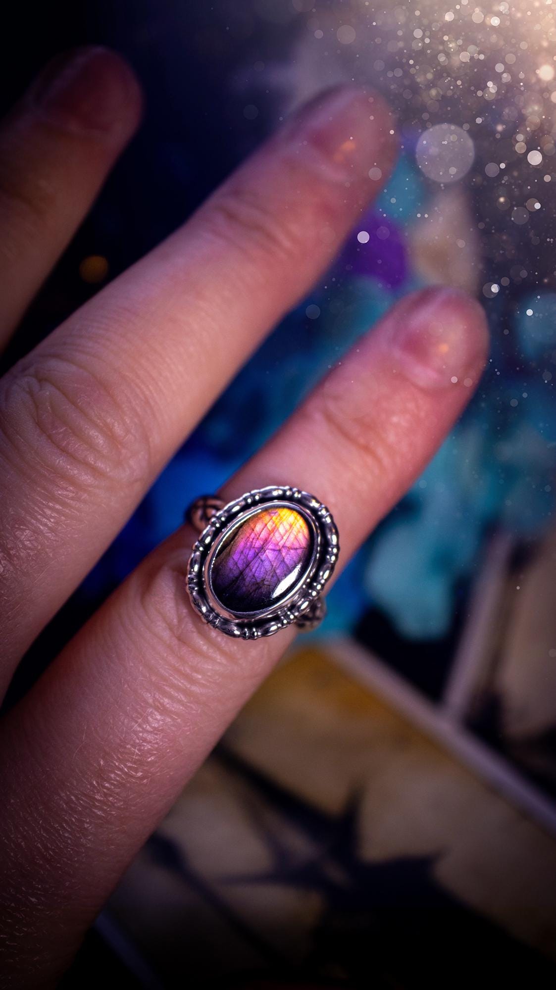 Handmade and very gothic, natural purple labradorite, sterling silver ring. This minimalist ring features a very pretty and flashy labradorite crystal that has a rich and vibrant purple colour. Around the crystal is a beautifully detail, gothic bezel that has been polished to a high lustre. The crystal is mounted on stamped ring shank. This ring would be ideal for anyone who loves jewellery and crystals, or who has a gothic and witchy style. A beautiful piece of jewellery to add to a collection