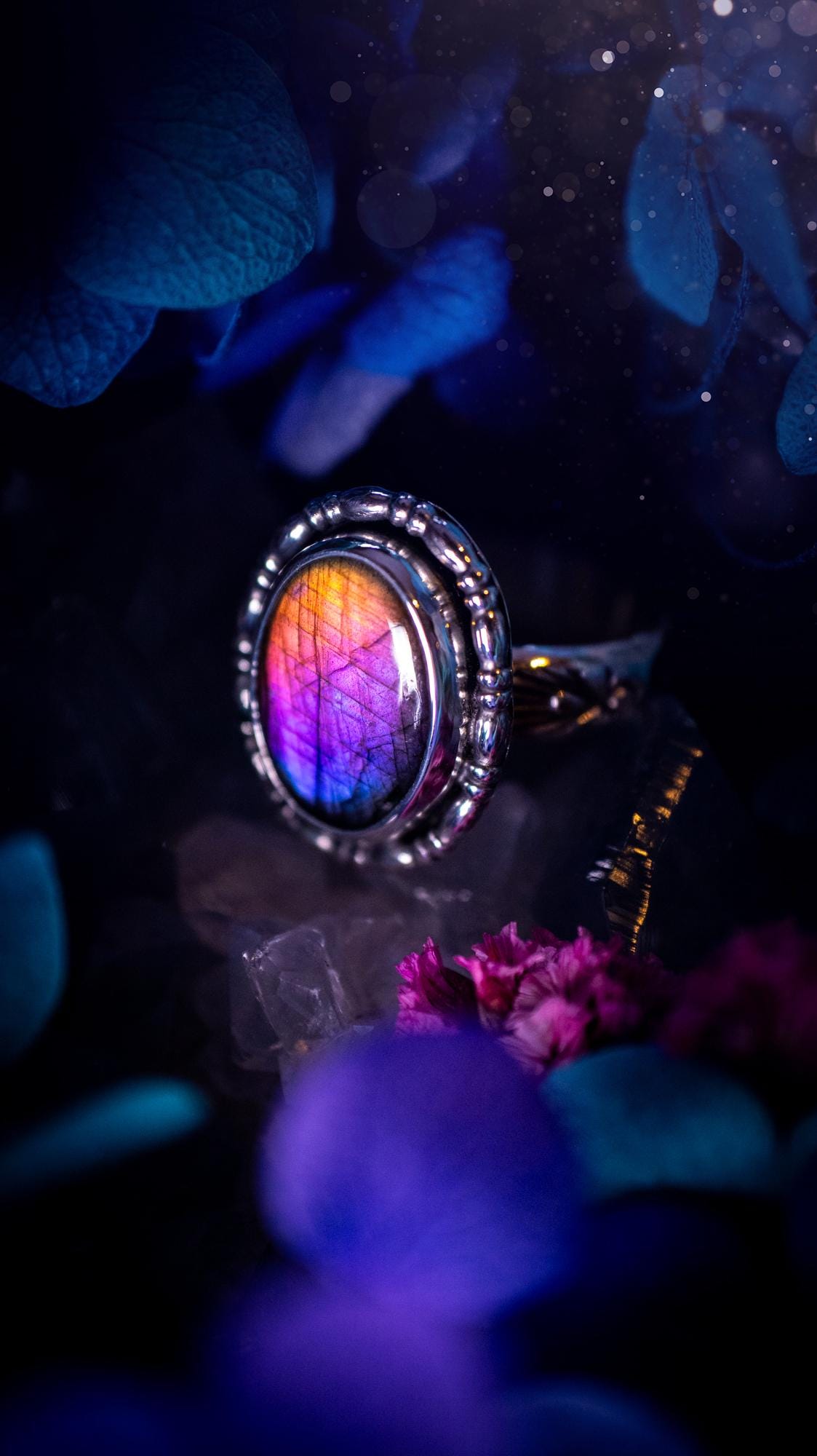 Handmade and very gothic, natural purple labradorite, sterling silver ring. This minimalist ring features a very pretty and flashy labradorite crystal that has a rich and vibrant purple colour. Around the crystal is a beautifully detail, gothic bezel that has been polished to a high lustre. The crystal is mounted on stamped ring shank. This ring would be ideal for anyone who loves jewellery and crystals, or who has a gothic and witchy style. A beautiful piece of jewellery to add to a collection