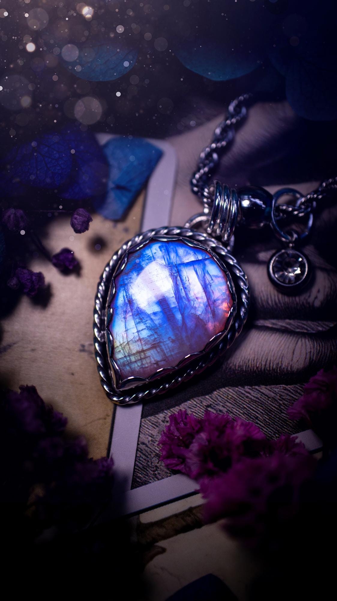 Handmade and bespoke, pink rainbow moonstone, sterling silver pendant necklace. This lovely pendant feature a very high quality rainbow moonstone that is full of gorgeous pink and blue flash. This unusual pink colour has been created by using materials under the stone so the pink hue shines through with the iridescence of the moonstone. Made from fine and sterling silver. An ideal piece for any crystal and jewellery lover. Moonstone is the birthstone for June. Unique gothic jewellery