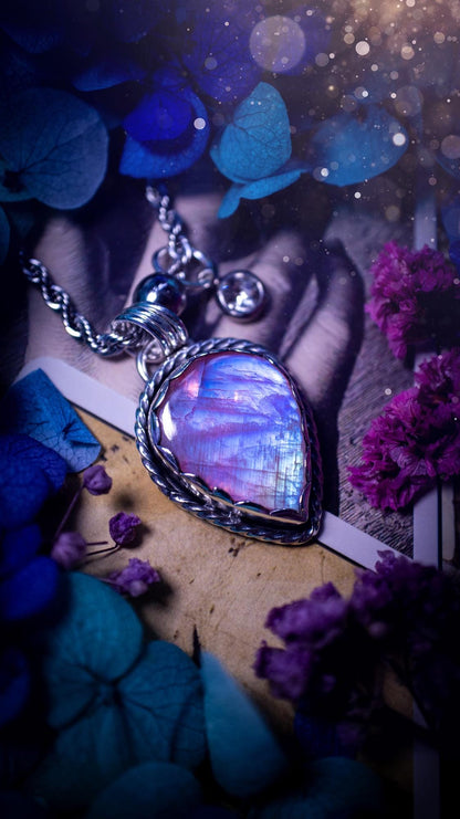 Handmade and bespoke, pink rainbow moonstone, sterling silver pendant necklace. This lovely pendant feature a very high quality rainbow moonstone that is full of gorgeous pink and blue flash. This unusual pink colour has been created by using materials under the stone so the pink hue shines through with the iridescence of the moonstone. Made from fine and sterling silver. An ideal piece for any crystal and jewellery lover. Moonstone is the birthstone for June. Unique gothic jewellery