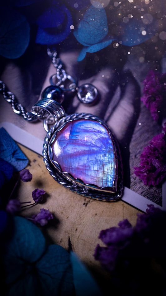 Handmade and bespoke, pink rainbow moonstone, sterling silver pendant necklace. This lovely pendant feature a very high quality rainbow moonstone that is full of gorgeous pink and blue flash. This unusual pink colour has been created by using materials under the stone so the pink hue shines through with the iridescence of the moonstone. Made from fine and sterling silver. An ideal piece for any crystal and jewellery lover. Moonstone is the birthstone for June. Unique gothic jewellery