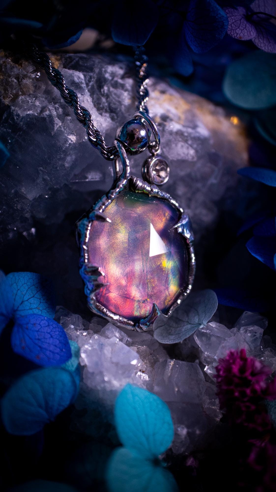 A beautiful, one of a kind, aurora opal pendant necklace. This little statement necklace is handmade using the tiffany technique, also known as soft soldering. Featuring the most stunning, and sparkly aurora opal which is full of pinks, greens and blues just like the northern lights. Aurora opals are man made opals that look similar to natural ones, they have a layer of rose quartz on top to give extra shine. The ideal gift for any crystal or jewellery lover. Gothic and witchy jewellery