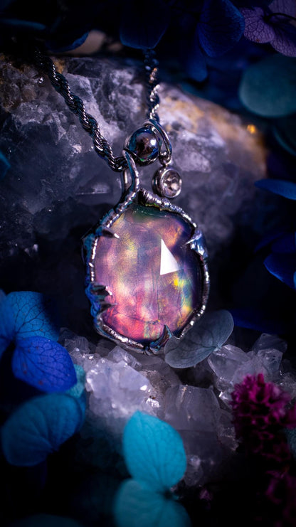 A beautiful, one of a kind, aurora opal pendant necklace. This little statement necklace is handmade using the tiffany technique, also known as soft soldering. Featuring the most stunning, and sparkly aurora opal which is full of pinks, greens and blues just like the northern lights. Aurora opals are man made opals that look similar to natural ones, they have a layer of rose quartz on top to give extra shine. The ideal gift for any crystal or jewellery lover. Gothic and witchy jewellery
