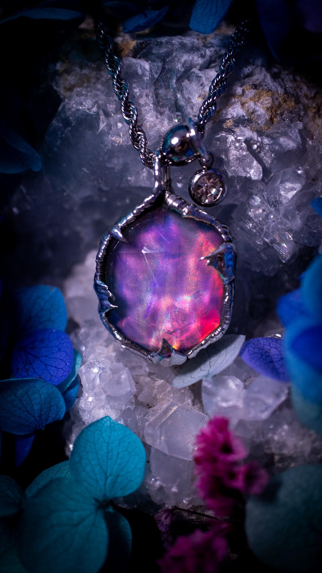 A beautiful, one of a kind, aurora opal pendant necklace. This little statement necklace is handmade using the tiffany technique, also known as soft soldering. Featuring the most stunning, and sparkly aurora opal which is full of pinks, greens and blues just like the northern lights. Aurora opals are man made opals that look similar to natural ones, they have a layer of rose quartz on top to give extra shine. The ideal gift for any crystal or jewellery lover. Gothic and witchy jewellery