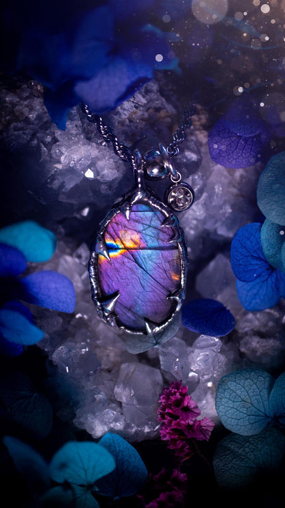 Beautifully handmade and bespoke, purple labradorite, soft soldered pendant necklace. This dainty labradorite pendant has been crafted using the soft solder method, also known as the tiffany technique. The crystal has a bezel of lead free soft solder which contains small parts of silver that allows for oxidisation and a high lustre polish. This labradorite is full of beautiful pinks, purples and has a lovely flash. One off, gothic and witchy jewellery with little claws on the bezel.