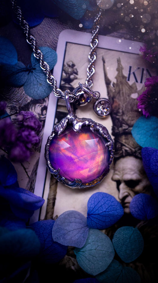 A beautiful, one of a kind, aurora opal pendant necklace. This little statement necklace is handmade using the tiffany technique, also known as soft soldering. Featuring the most stunning, and sparkly aurora opal which is full of pinks, greens and blues just like the northern lights. Aurora opals are man made opals that look similar to natural ones, they have a layer of rose quartz on top to give extra shine. The ideal gift for any crystal or jewellery lover. Gothic and witchy jewellery