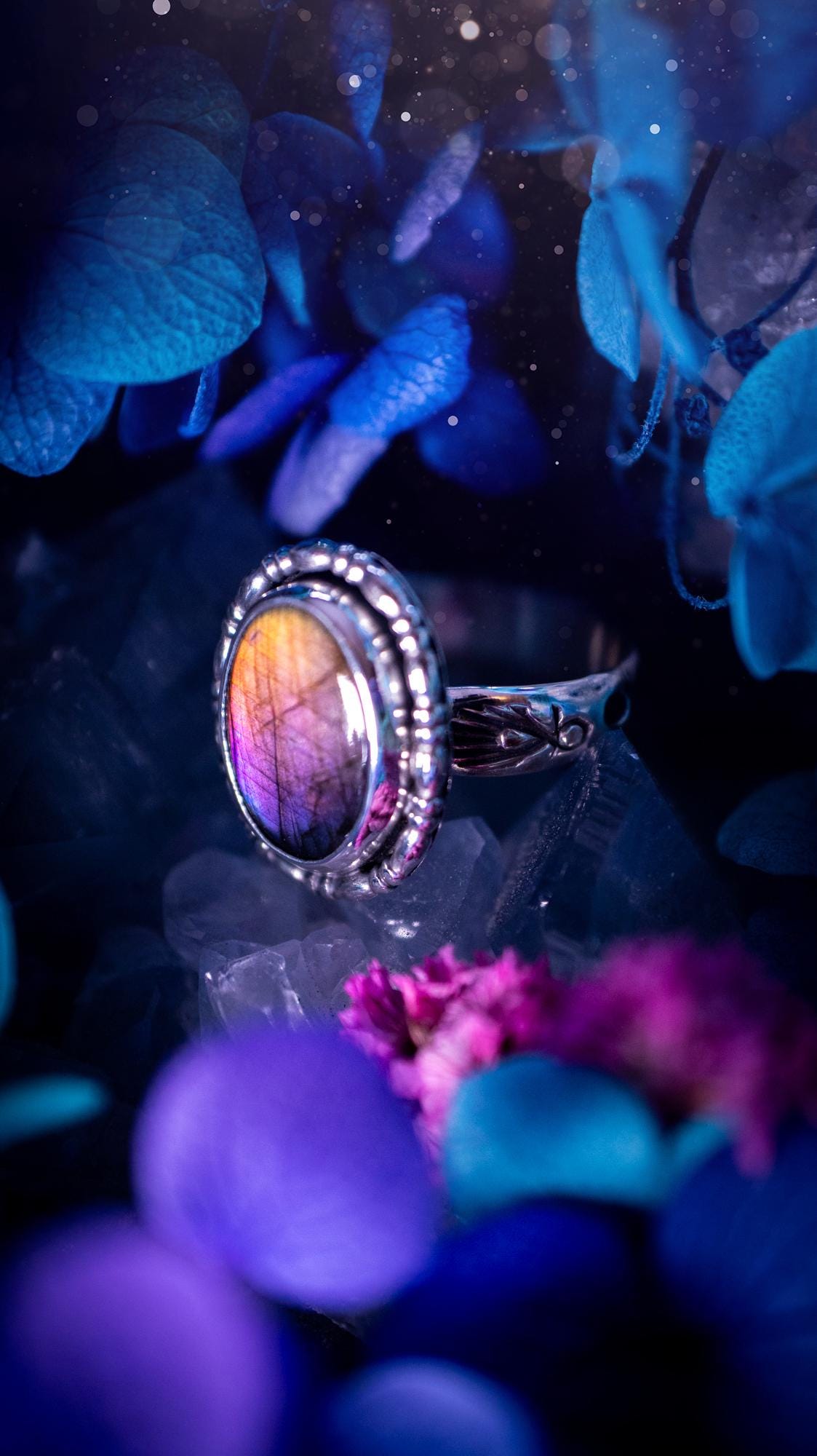 Handmade and very gothic, natural purple labradorite, sterling silver ring. This minimalist ring features a very pretty and flashy labradorite crystal that has a rich and vibrant purple colour. Around the crystal is a beautifully detail, gothic bezel that has been polished to a high lustre. The crystal is mounted on stamped ring shank. This ring would be ideal for anyone who loves jewellery and crystals, or who has a gothic and witchy style. A beautiful piece of jewellery to add to a collection