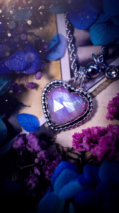 Handmade and bespoke, pink rainbow moonstone heart, sterling silver pendant necklace. This lovely pendant feature a very high quality rainbow moonstone that is full of gorgeous pink and blue flash. This unusual pink colour has been created by using materials under the stone so the pink hue shines through with the iridescence of the moonstone. Made from fine and sterling silver. An ideal piece for any crystal and jewellery lover. Moonstone is the birthstone for June. Unique gothic jewellery