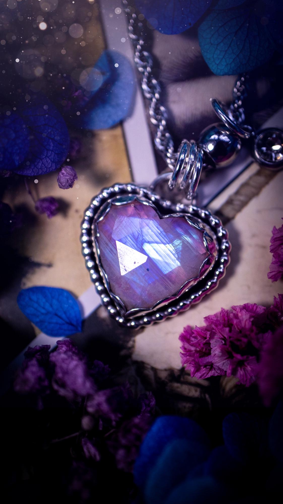 Handmade and bespoke, pink rainbow moonstone heart, sterling silver pendant necklace. This lovely pendant feature a very high quality rainbow moonstone that is full of gorgeous pink and blue flash. This unusual pink colour has been created by using materials under the stone so the pink hue shines through with the iridescence of the moonstone. Made from fine and sterling silver. An ideal piece for any crystal and jewellery lover. Moonstone is the birthstone for June. Unique gothic jewellery