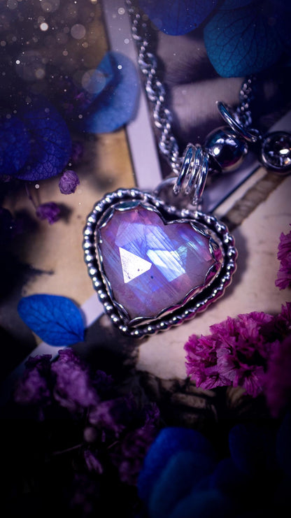 Handmade and bespoke, pink rainbow moonstone heart, sterling silver pendant necklace. This lovely pendant feature a very high quality rainbow moonstone that is full of gorgeous pink and blue flash. This unusual pink colour has been created by using materials under the stone so the pink hue shines through with the iridescence of the moonstone. Made from fine and sterling silver. An ideal piece for any crystal and jewellery lover. Moonstone is the birthstone for June. Unique gothic jewellery