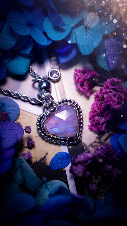 Handmade and bespoke, pink rainbow moonstone heart, sterling silver pendant necklace. This lovely pendant feature a very high quality rainbow moonstone that is full of gorgeous pink and blue flash. This unusual pink colour has been created by using materials under the stone so the pink hue shines through with the iridescence of the moonstone. Made from fine and sterling silver. An ideal piece for any crystal and jewellery lover. Moonstone is the birthstone for June. Unique gothic jewellery